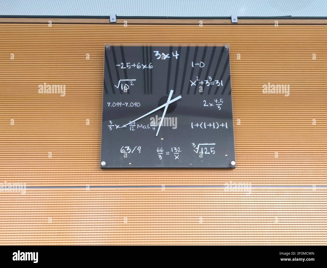 Horloge murale avec équations mathématiques sur le cadran noir montée sur un mur extérieur moderne Banque D'Images