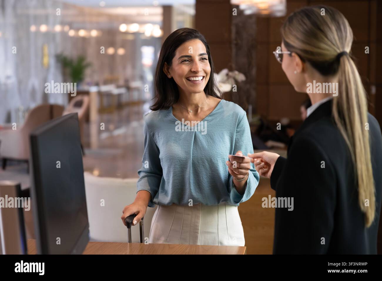 Client d'hôtel recevant une carte-clé au comptoir de réception Banque D'Images