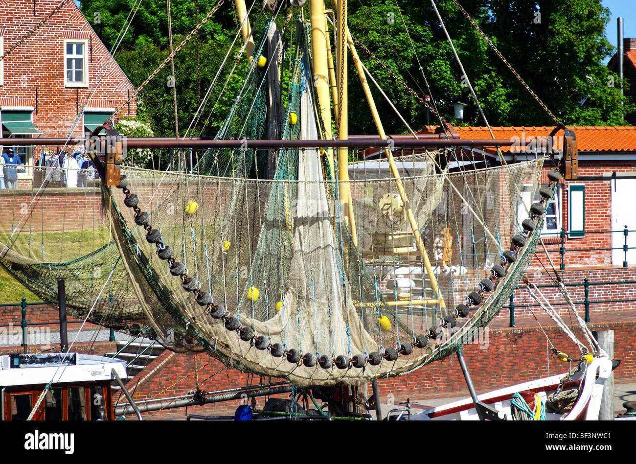 Filet de pêche du chalutier Greetsiel séchant dans le port. Les filets sont suspendus au mât du bateau, symbolisant la pêche maritime traditionnelle Banque D'Images