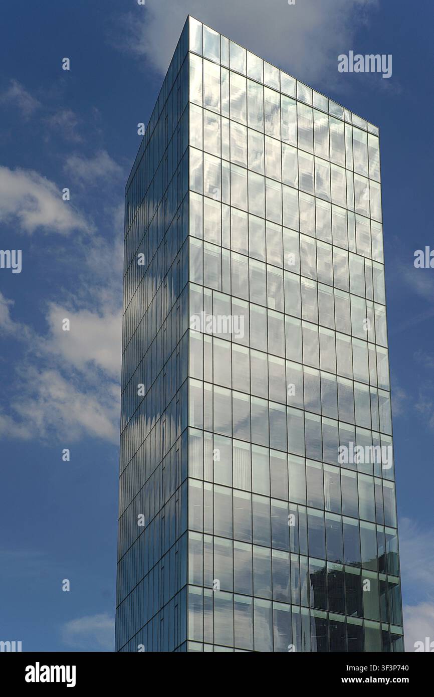 Un bâtiment architectural moderne et élégant présentant des éléments de design contemporain en verre et en métal sous un ciel dégagé Banque D'Images