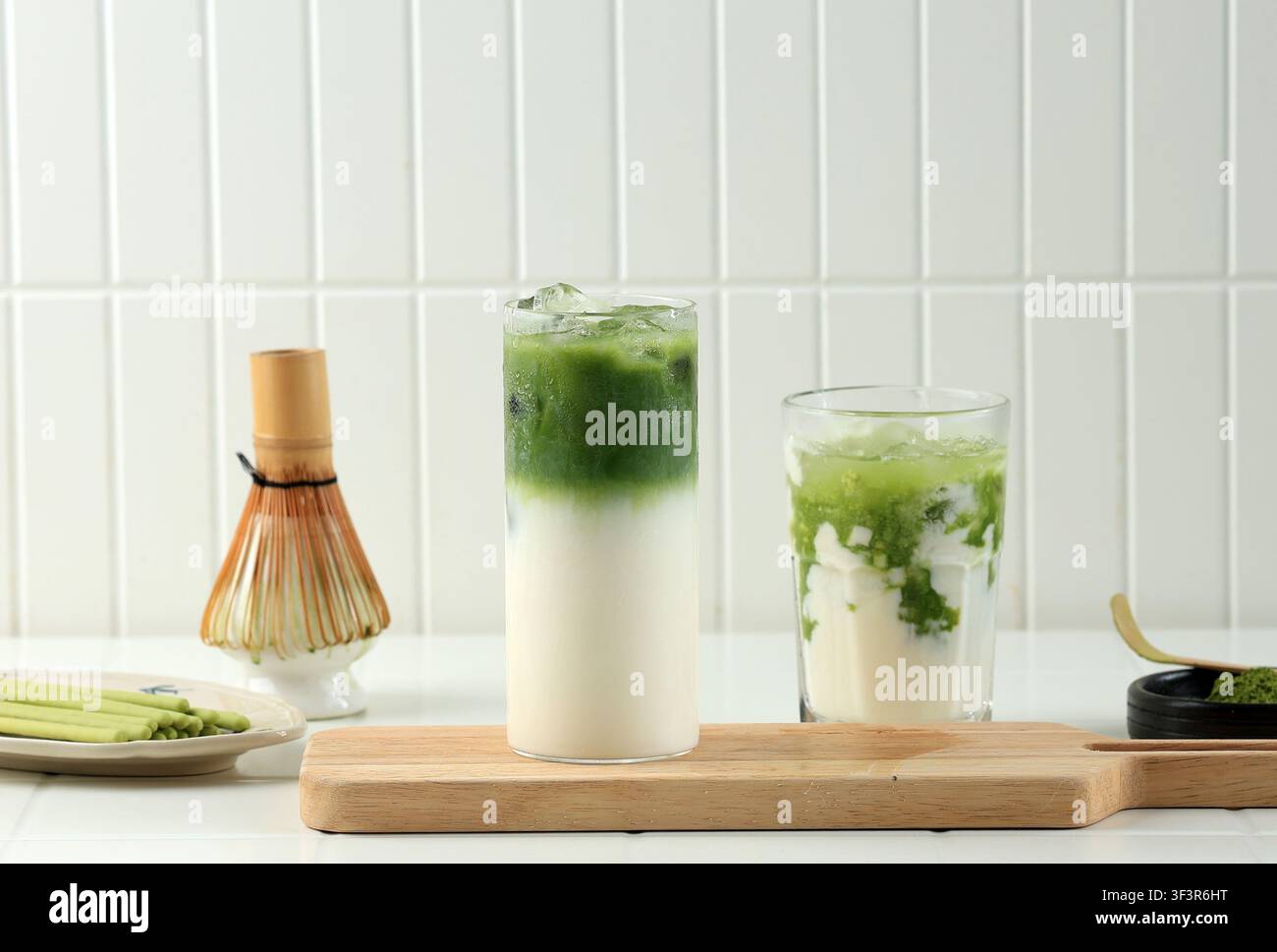 Latte Matcha glacé dans un verre sur fond blanc. Boisson rafraîchissante au thé vert avec du lait dans un verre transparent pour concepts de boissons Banque D'Images