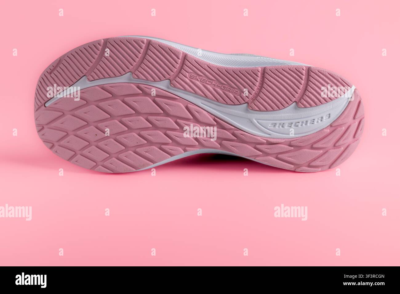 Lviv, Ukraine - 25 juillet 2026 : Vue inférieure de la semelle de baskets de course roses Skechers avec motif de rainure sur fond rose Banque D'Images