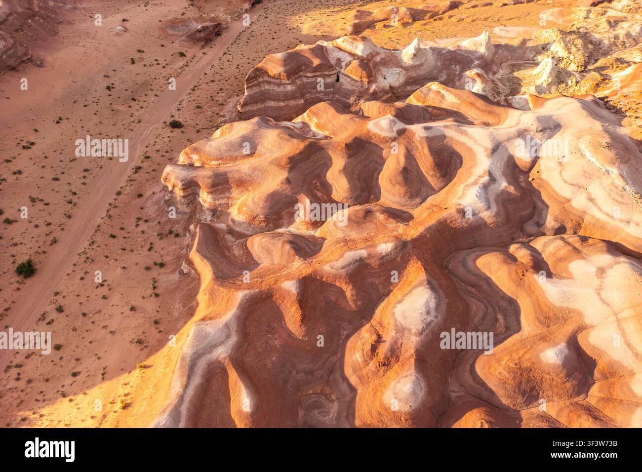 Photographie aérienne de formations de grès colorées façonnées par l'érosion, créant des motifs tourbillonnants et un fond texturé frappant de désert dans l'Utah, États-Unis Banque D'Images