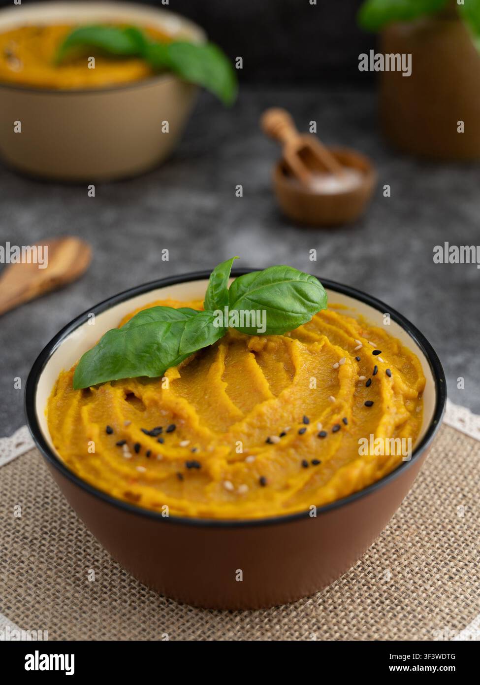 Soupe automnale crémeuse servie dans un bol en céramique avec mise au point sélective et atmosphère saisonnière chaleureuse Banque D'Images