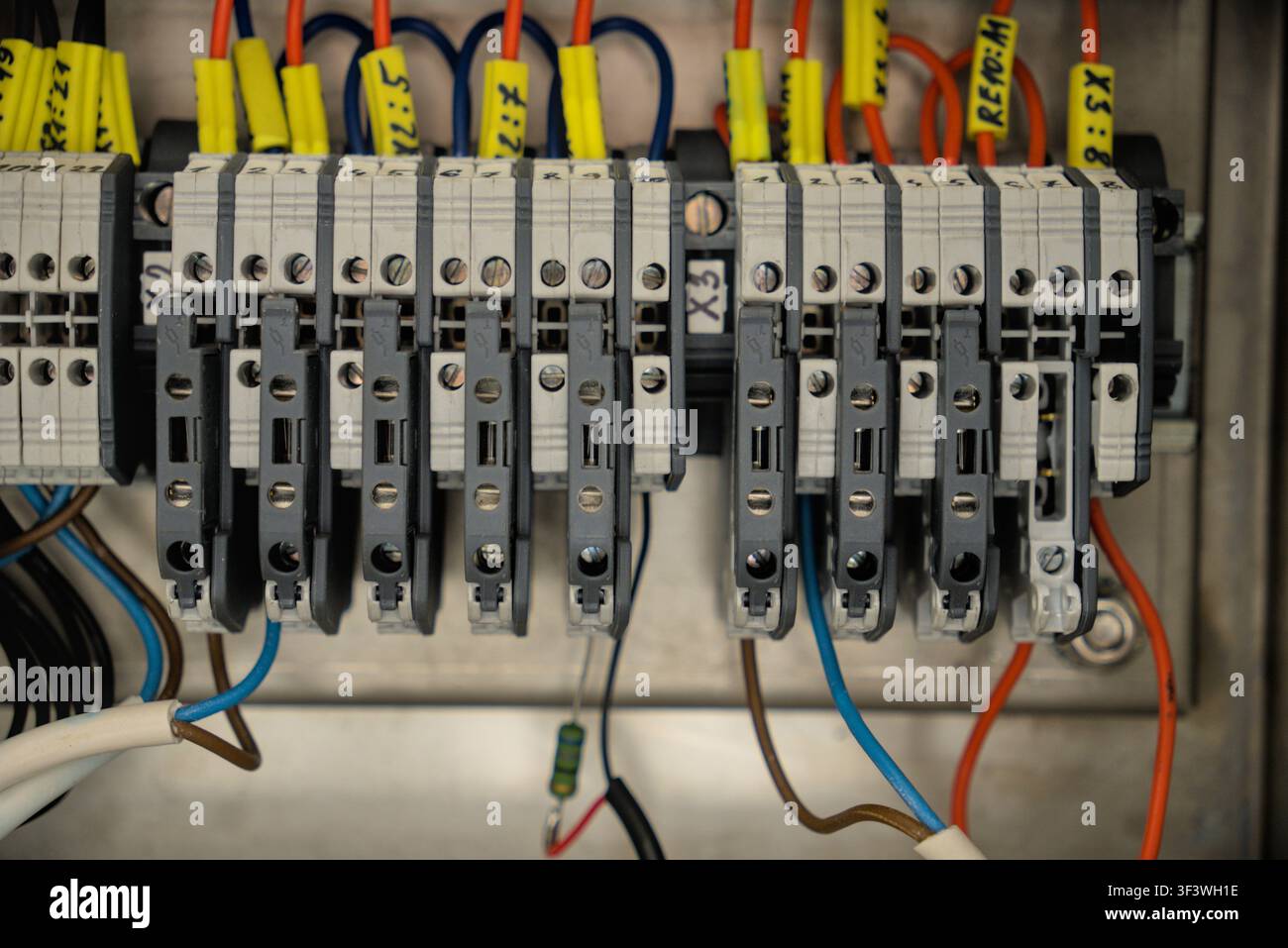 Grossissement des bornes électriques industrielles avec marqueurs de fils et câbles numérotés dans un armoire de contrôle. Banque D'Images