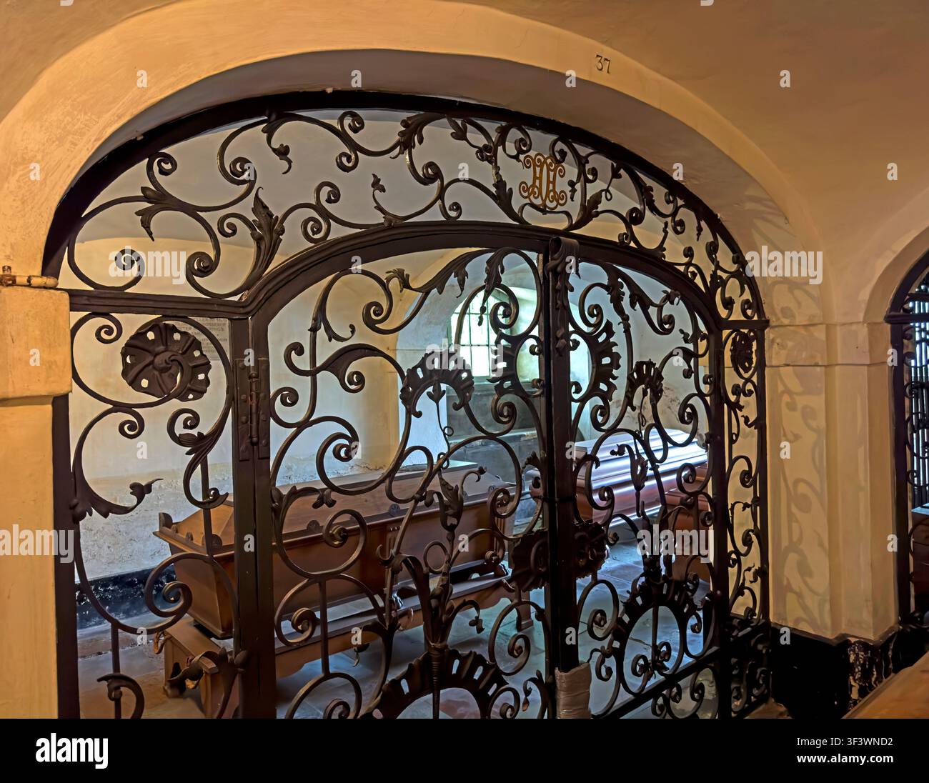 Porte en fer forgé décorative avec des cercueils en bois visibles à l'intérieur d'un espace intérieur, Copenhague - cercueils en bois dans la crypte sous l'église Christians Banque D'Images