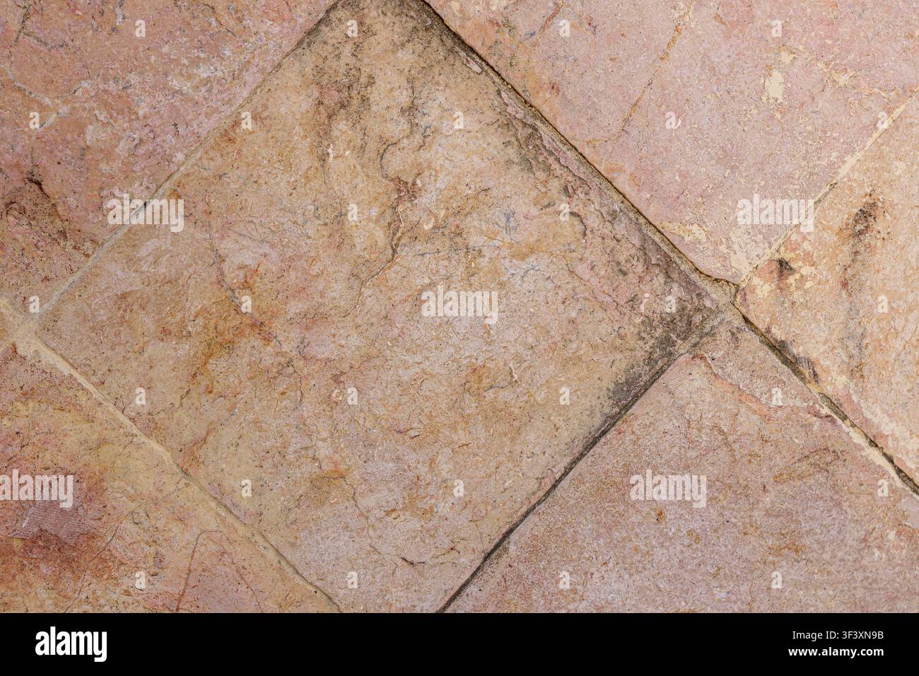 Vue rapprochée en plan vertical de carreaux en terre cuite rustiques vintage placés en diagonale sur une surface de sol avec une texture naturelle usée. Photo de haute qualité Banque D'Images