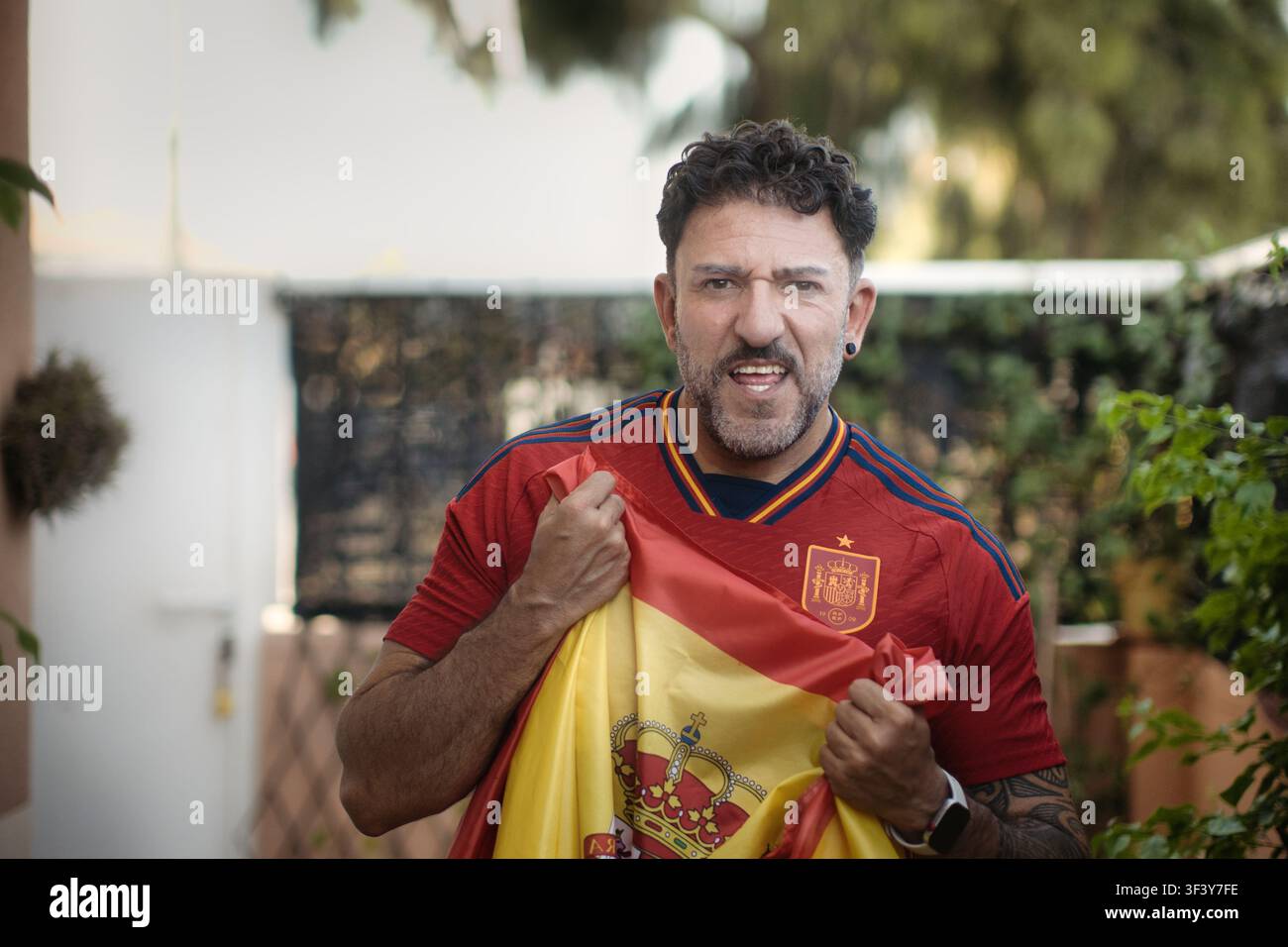 Supporter espagnol de football enthousiaste criant avec une intensité émotionnelle en plein air Banque D'Images