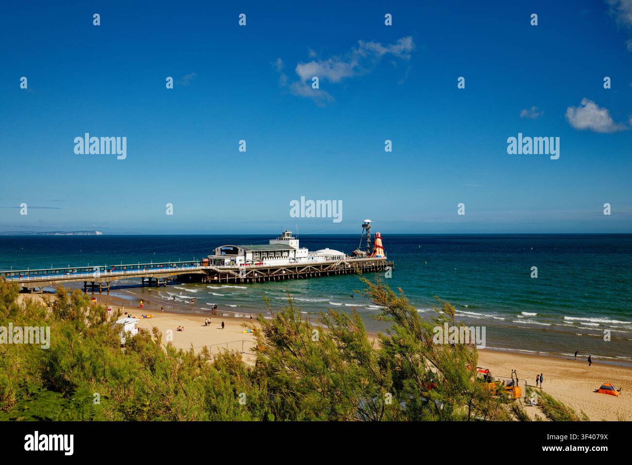 Une jetée en bord de mer s'avance dans une mer bleu profond sous un ciel bleu presque sans nuages, Bournemouth, Dorset, Angleterre. Banque D'Images