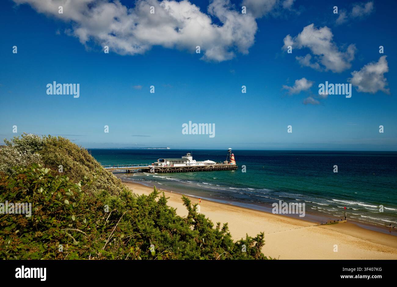 Une jetée en bord de mer s'avance dans une mer bleu profond sous un ciel bleu presque sans nuages, Bournemouth, Dorset, Angleterre. Banque D'Images