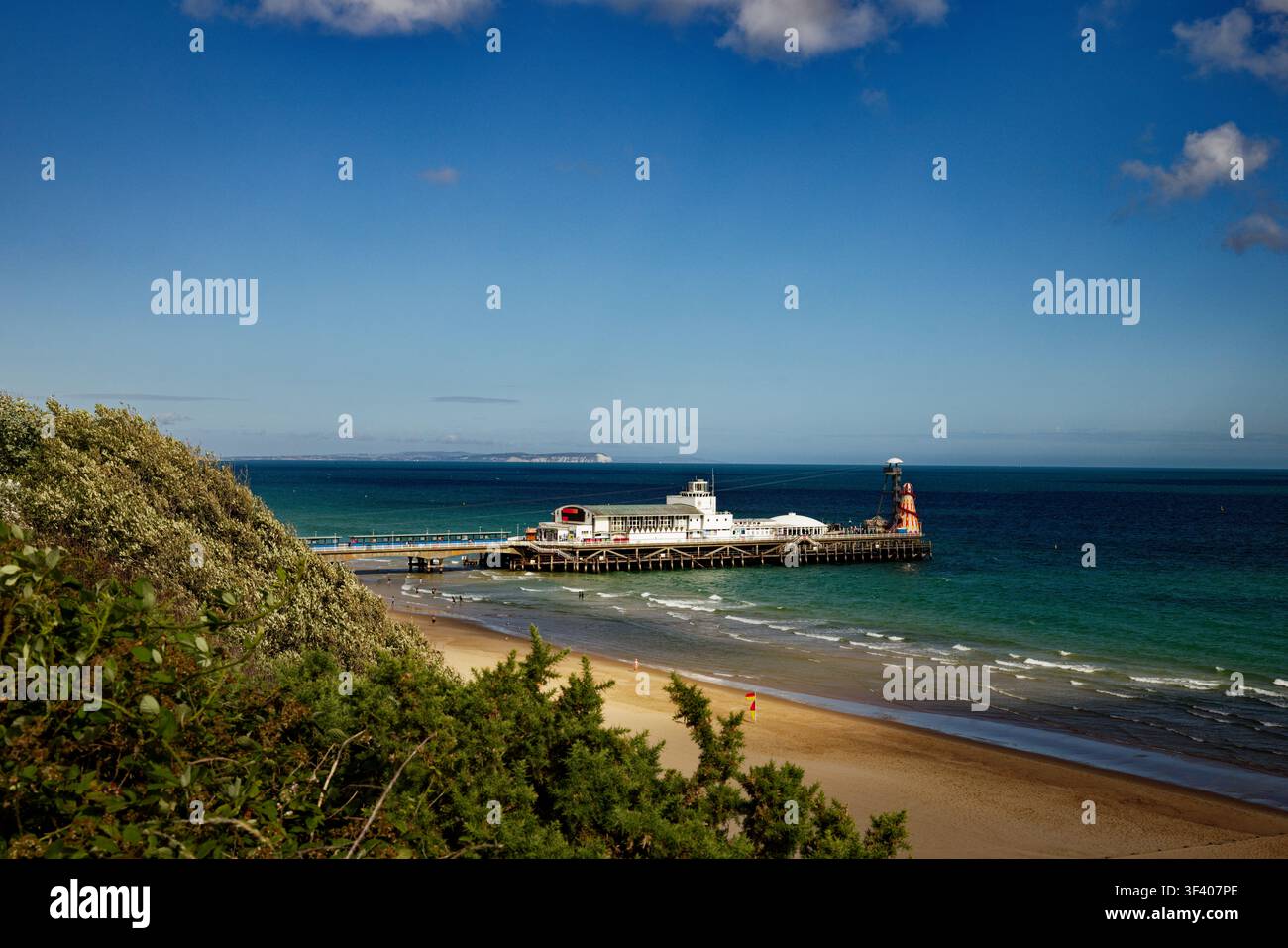 Une jetée en bord de mer s'avance dans une mer bleu profond sous un ciel bleu presque sans nuages, Bournemouth, Dorset, Angleterre. Banque D'Images