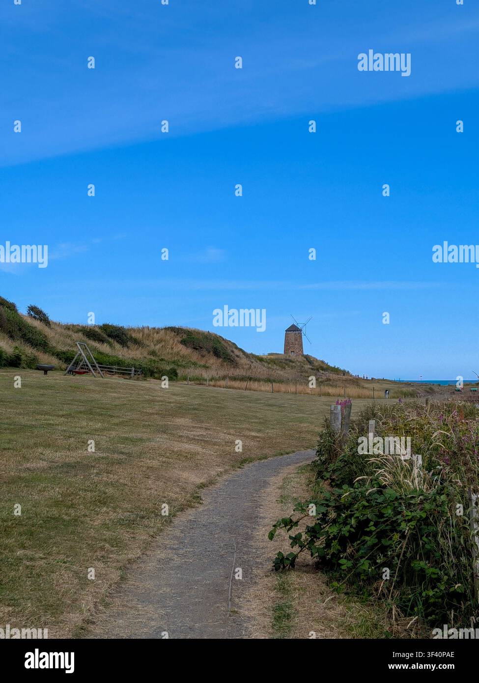 Le moulin historique de St Monans se dresse près du rivage le long d'un sentier de terre pittoresque dans le Fife, en Écosse. - Image de stock capturée avec un smartphone