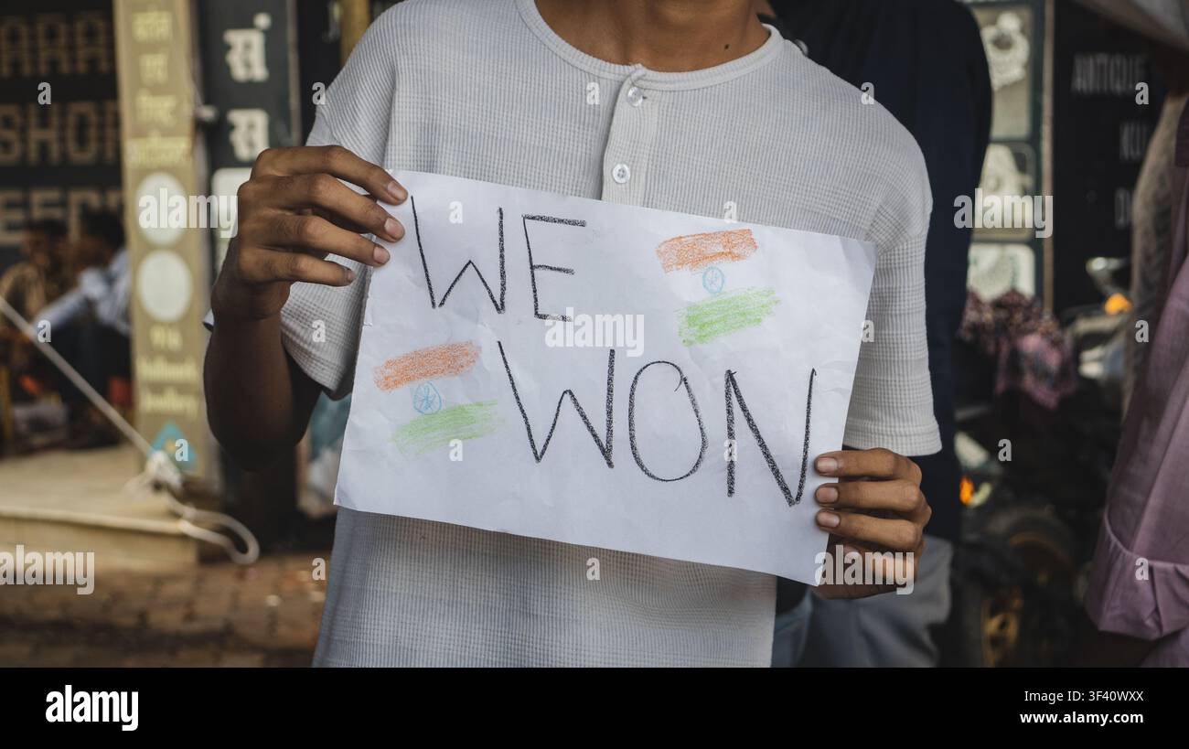 Panneau "Nous avons gagné" écrit à la main tenu par un étudiant lors d'une manifestation de victoire à Bhopal Banque D'Images