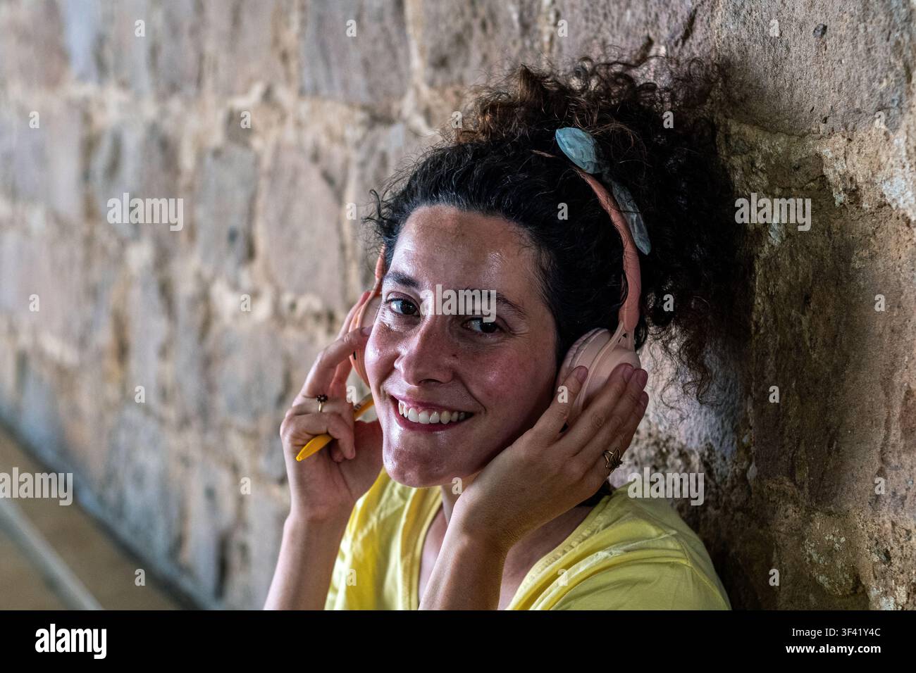 Femme souriant joyeusement en écoutant de la musique avec un casque Banque D'Images