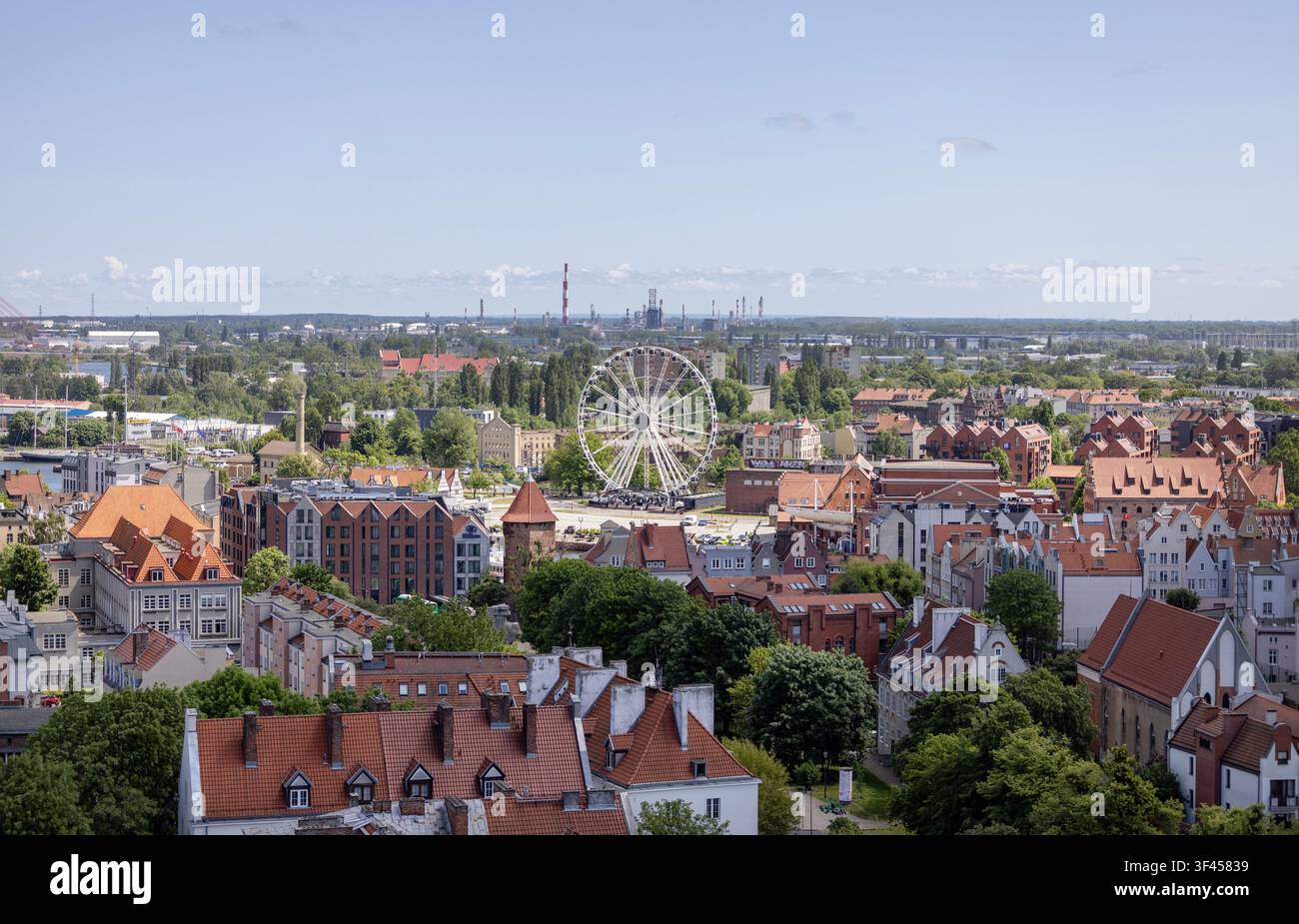 Dans la ville de Gdańsk, Pologne - 2 juin 2023 : Grande roue AmberSky sur l'île d'Ołowianka et toits historiques de la ville. Vue aérienne depuis la tour de l'église Sainte-Catherine Banque D'Images