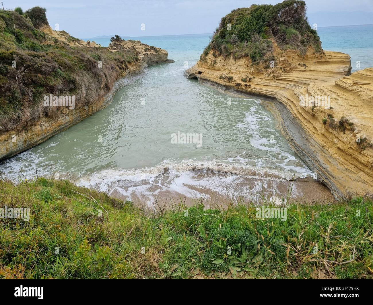 Falaises de grès stratifiées du canal maritime étroit Canal d'Amour avec des vagues se brisant sur le sable, Sidari, nord de Corfou, îles ioniennes, Grèce - Image de stock capturée avec un smartphone