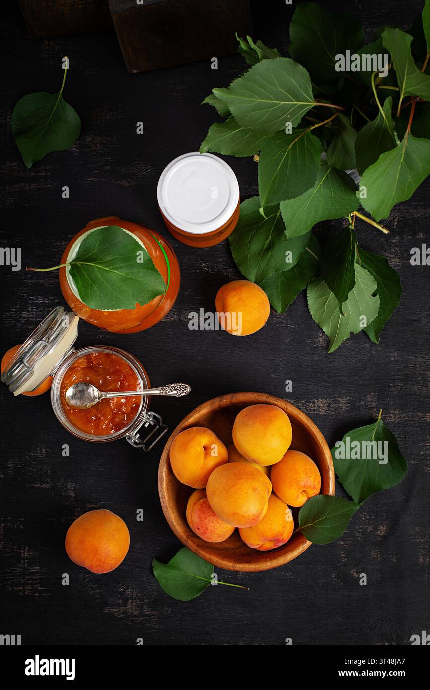 Confiture d'abricot maison en pots sur fond sombre. Vue de dessus Banque D'Images