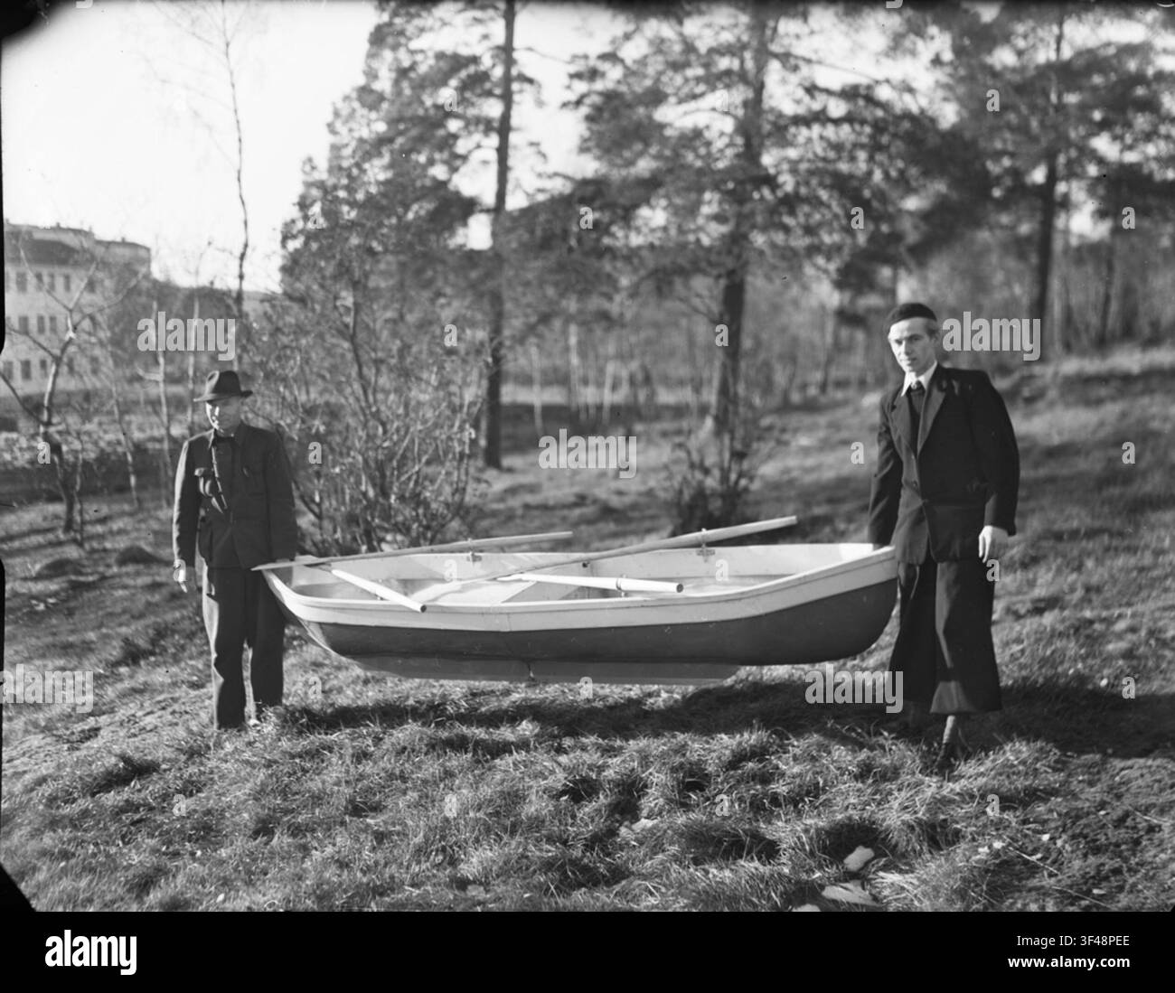 Un bateau pliant avec deux rames, porté par deux hommes. Banque D'Images