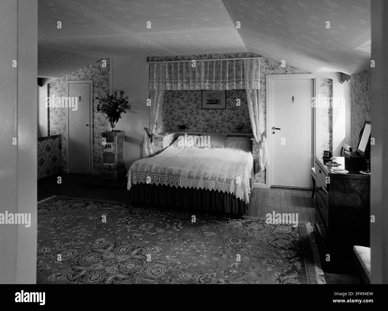 Intérieur d'une chambre à coucher avec un lit à baldaquin et un papier peint à petits fleurs, conçu par Ulla Bodorff, une architecte suédoise. Banque D'Images