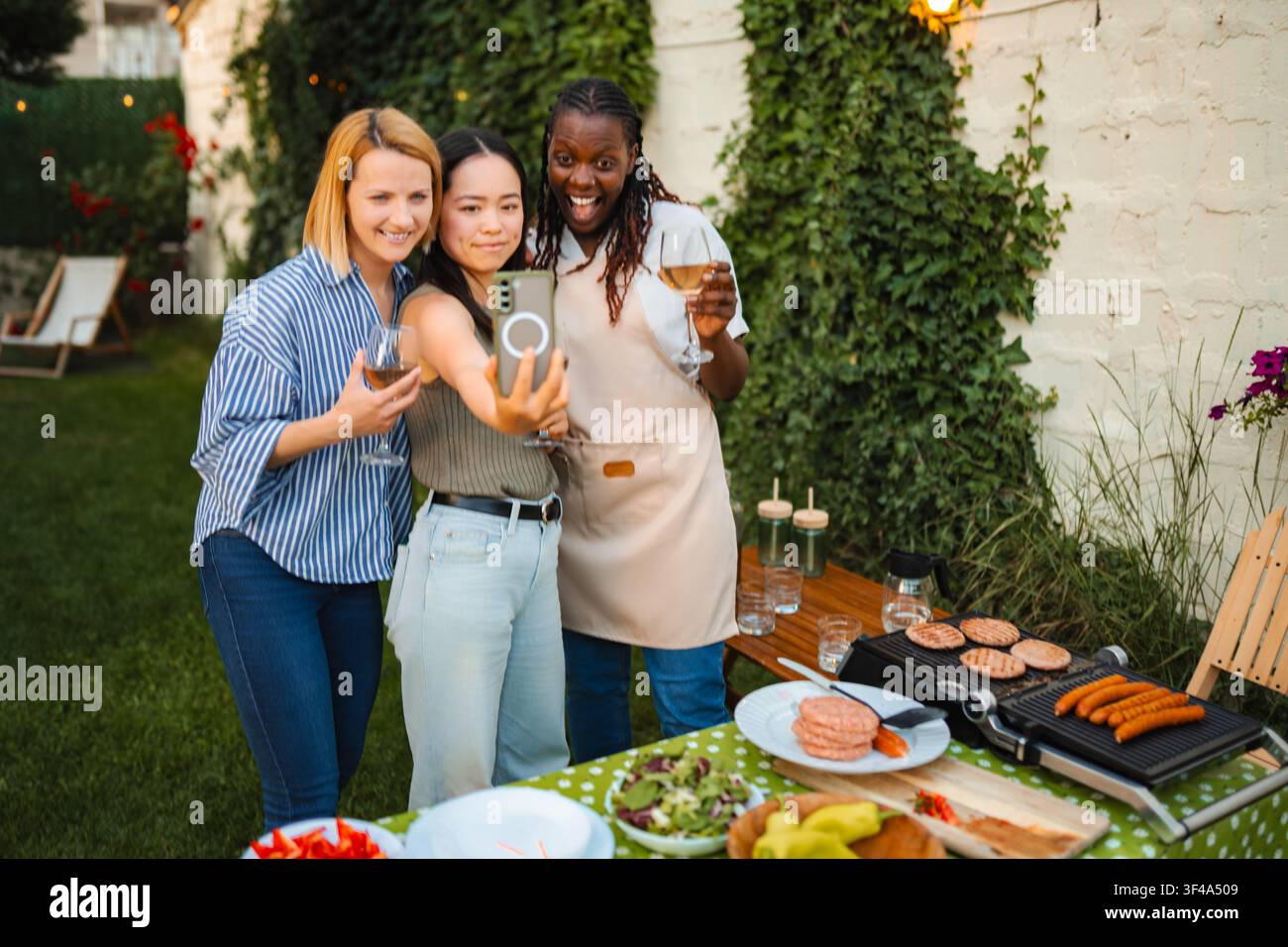 Diverses amies femmes prenant un selfie lors d'une fête barbecue Banque D'Images