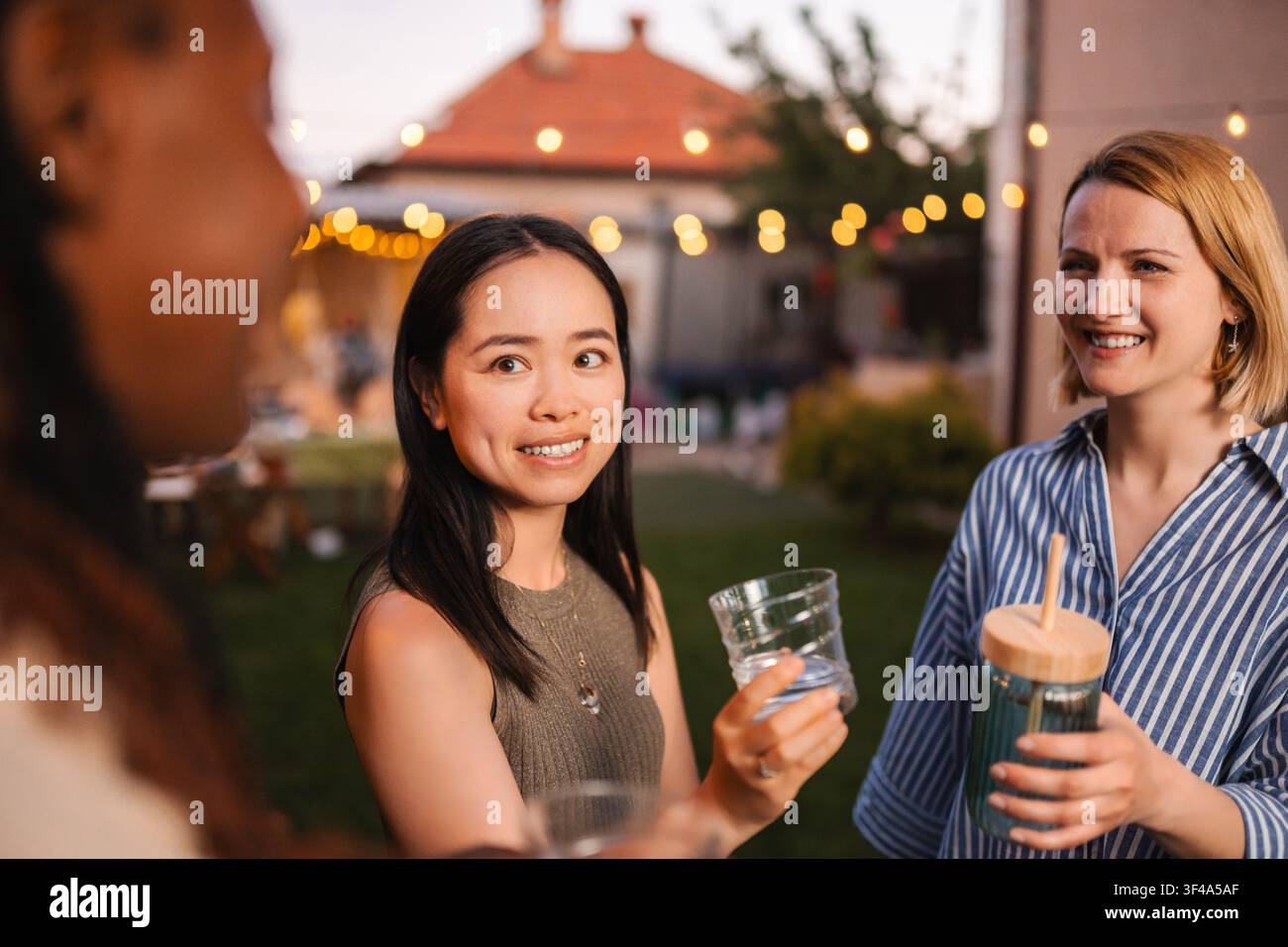 Des amis divers profitant ensemble d'une fête d'été dans le jardin Banque D'Images