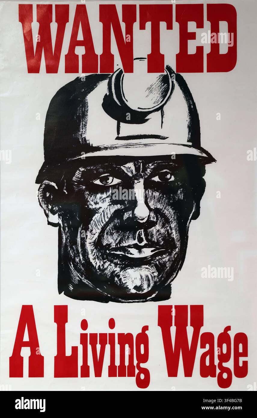 Affiche « Wanted A Living Wage » montrant le visage et le casque d'un mineur, photographiée en Grande-Bretagne. Banque D'Images