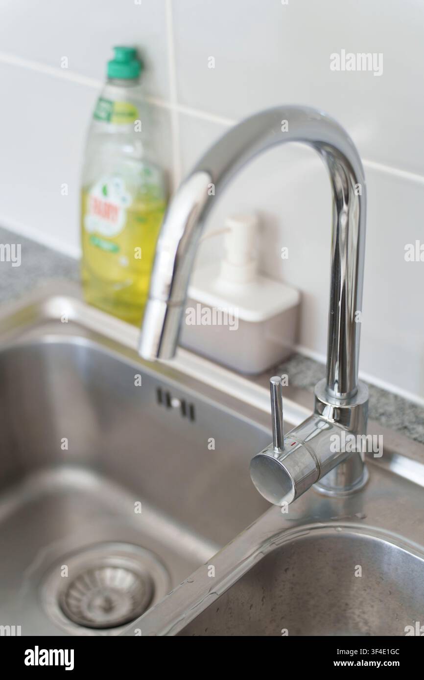 Robinet chrom moderne et évier de cuisine en acier inoxydable avec bouteille de liquide vaisselle Banque D'Images