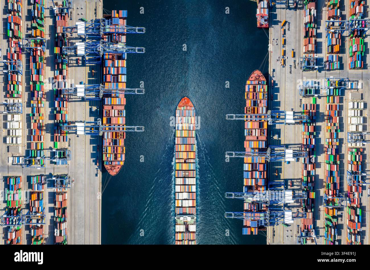 Vue aérienne de dessus d'un grand terminal de conteneurs pour cargos avec activité de chargement et trafic de navires Banque D'Images
