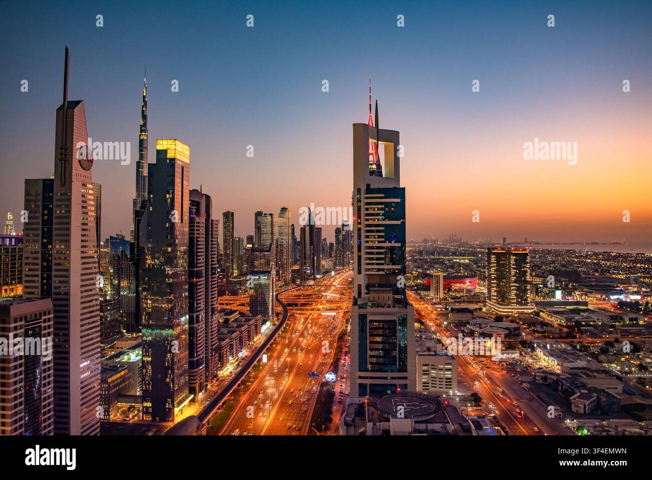 Vue élevée au coucher du soleil des voies de circulation de Sheikh Zayed Road et des gratte-ciel, y compris la Burj Khalifa à Dubaï, Émirats arabes unis. Banque D'Images