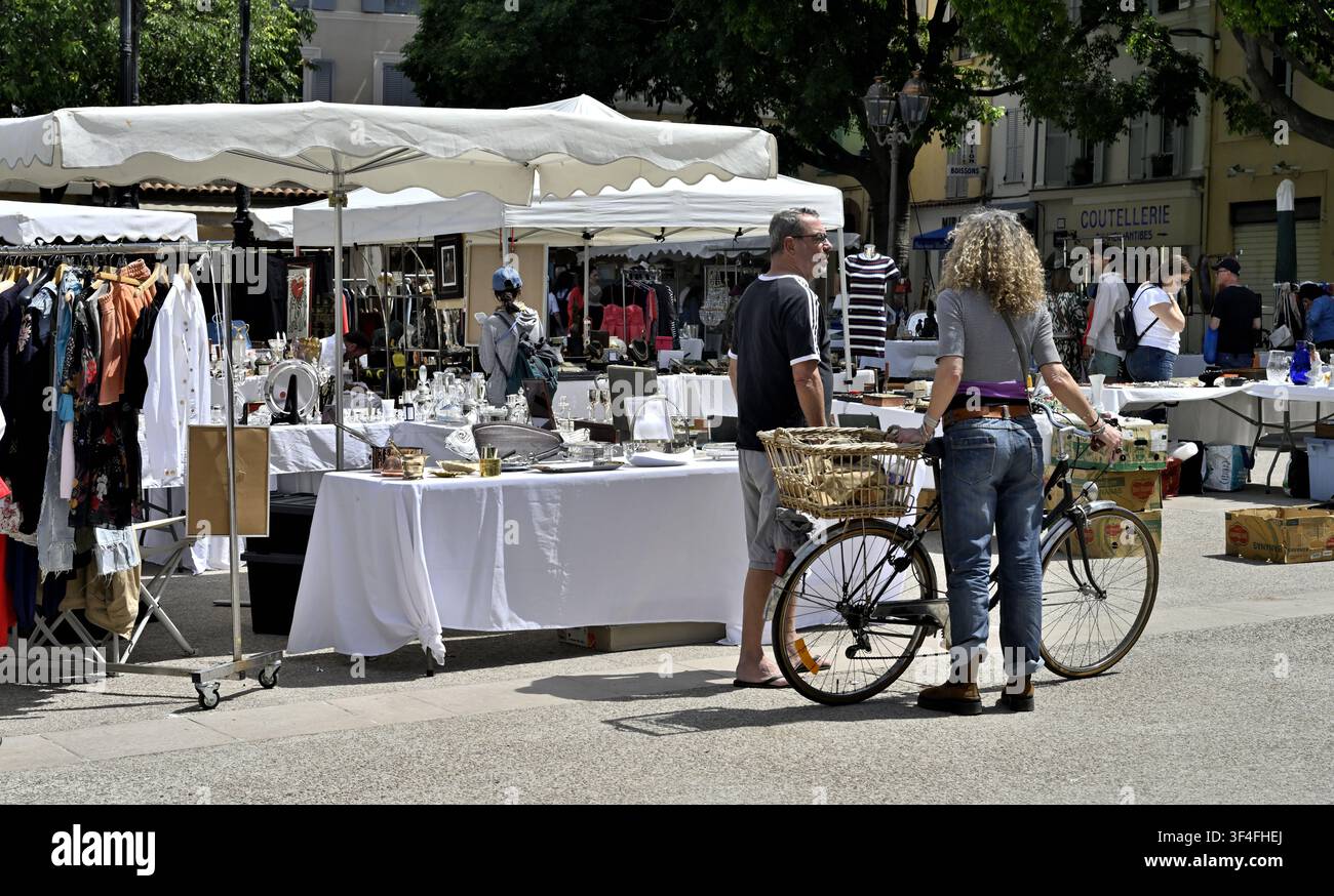 Scène de rue d'un marché de samedi en plein air et femme avec vélo observant, Antibes, France Banque D'Images
