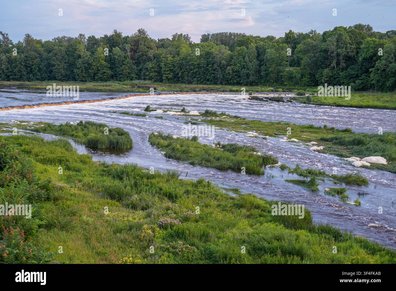 Vue panoramique de la rivière Venta et de la plus large cascade d'Europe à Kuldiga en Lettonie à la lumière du soir d'été Banque D'Images