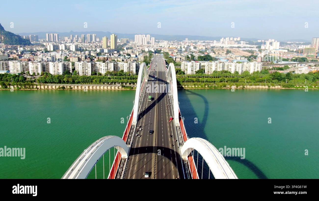 LIUZHOU, CHINE - 15 OCT. 2023 : Vue aérienne regardant droit le long d'un pont en arche blanc traversant la rivière Liu turquoise à Liuzhou, Guangxi, Chine. Banque D'Images