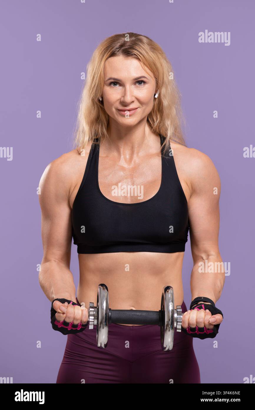 Exercices physiques, style de vie sportif. Belle dame sportswoman en uniforme de sport faisant de l'exercice avec haltères Banque D'Images