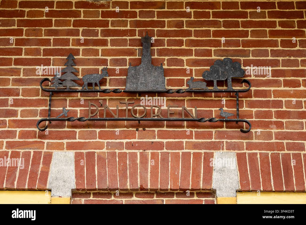 Vue de la plaque métallique pour De Brandtoren représentant des silhouettes d'une tour, d'un cerf et d'un lapin fixées sur un mur de briques rouges à Esbeek, Noord-Brabant, Banque D'Images
