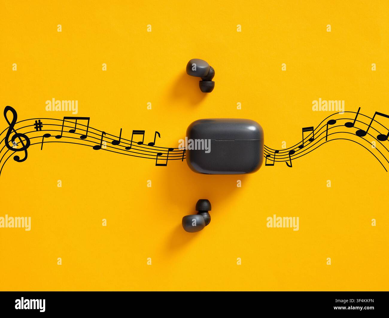 Concept d'écoute de musique. Écouteurs sans fil avec leur boîtier de recharge intégrant un portée musicale avec des notes de musique noires sur fond jaune Banque D'Images