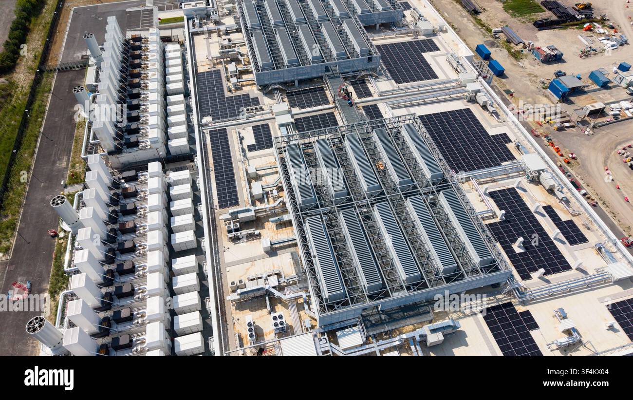 Vue aérienne d'un grand centre de données hyperscale présentant des rangées d'unités de refroidissement, des panneaux solaires sur le toit et une infrastructure industrielle à Set Banque D'Images