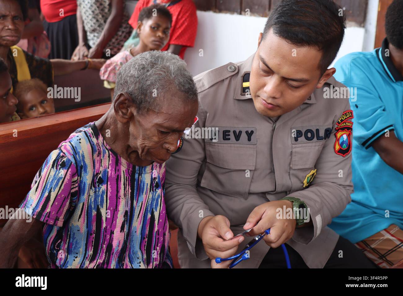 Un officier de police indonésien fournit une assistance médicale à une femme papoue âgée lors d'un programme de sensibilisation sanitaire à Papouasie, en Indonésie. Banque D'Images