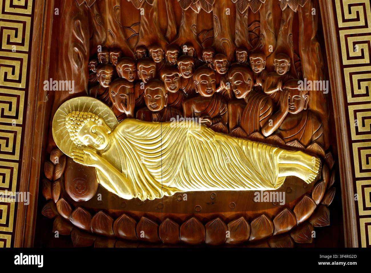 Pagode de Bai Dinh. Une sculpture en bois représentant le Bouddha couché, entouré de ses disciples, symbolisant son entrée dans le parinirvana. Cette religieuse Banque D'Images