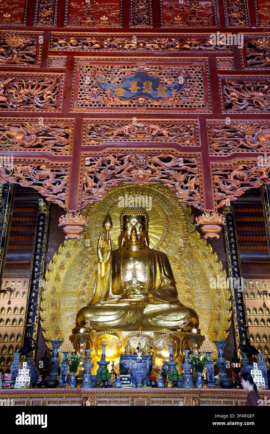 Pagode de Bai Dinh. L'intérieur d'un temple bouddhiste orné de sculptures dorées et de détails architecturaux complexes. Une statue de Bouddha Shakyamuni s Banque D'Images