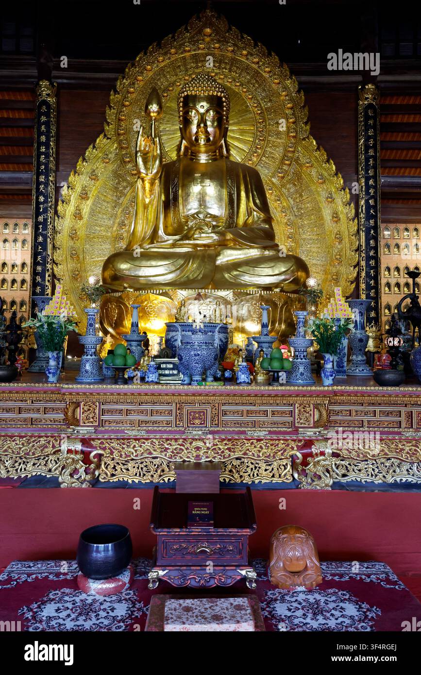 Pagode de Bai Dinh. L'intérieur d'un temple bouddhiste orné de sculptures dorées et de détails architecturaux complexes. Une statue de Bouddha Shakyamuni s Banque D'Images