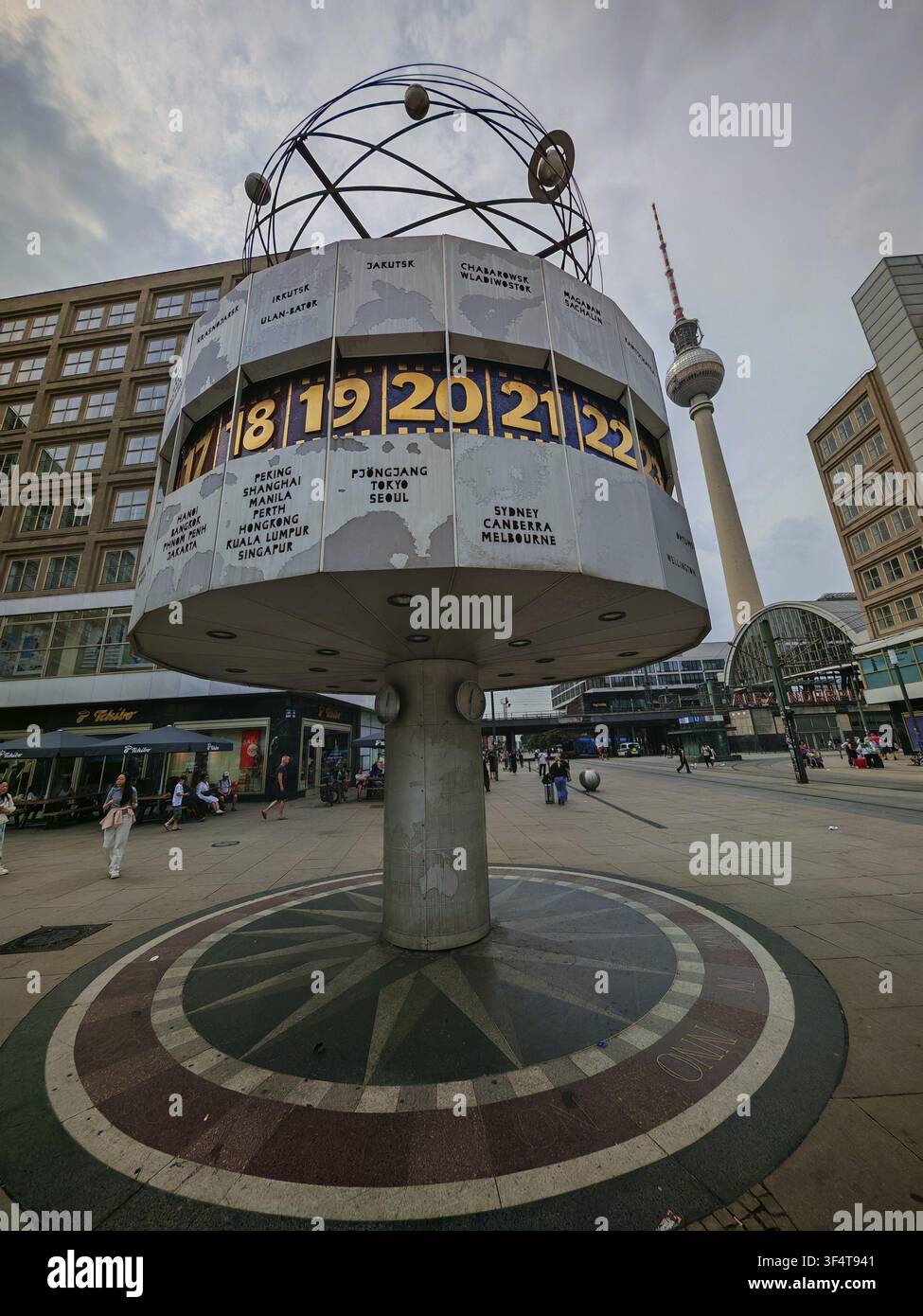L'horloge mondiale sur l'Alexanderplatz avec la tour de télévision de Berlin au loin par une journée nuageuse, Alexanderplatz, Berlin Banque D'Images
