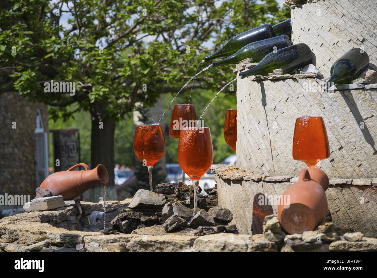 Fontaine de vin avec des boissons rouges dans des verres, provenant de bouteilles qui coulent sur la maçonnerie, fontaine avec des bouteilles de vin remplissant des verres, Domaine viticole Milestii Mici, Milestii Banque D'Images