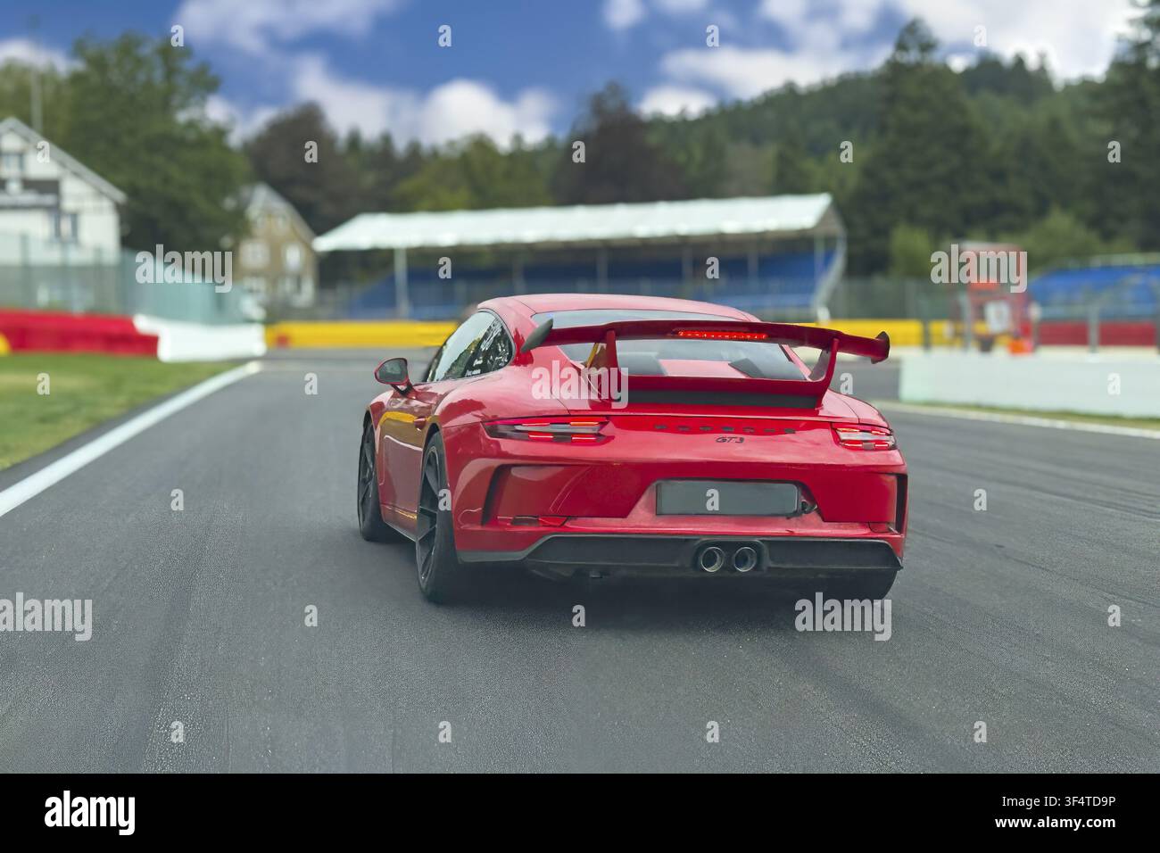 Voiture de sport Porsche 911 GT3 rouge freine au point de freinage devant le virage La Source à la fin de la ligne droite de départ/arrivée de la piste de course FIA F1 WEC Motorsp Banque D'Images