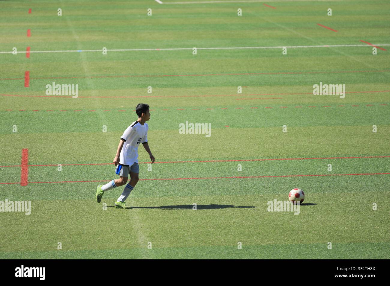 Élève japonais du collège jouant au football (13 ans) Banque D'Images
