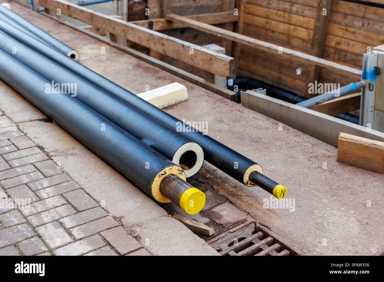 Le nouveau site de construction d'une installation de pipelines urbains isolés modernes a exposé les tuyaux souterrains dans des tranchées étayées. Raccordement de tuyaux en acier isolés Banque D'Images