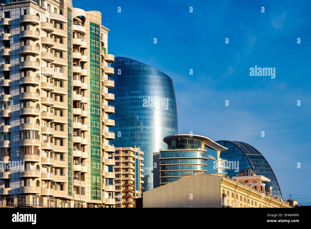 Immeubles résidentiels en hauteur contrastant avec les façades en verre du Port Baku Tower 2 et du Crescent Hotel sur la ligne d'horizon de Bakou. Bakou, Azerbaïdjan. Banque D'Images