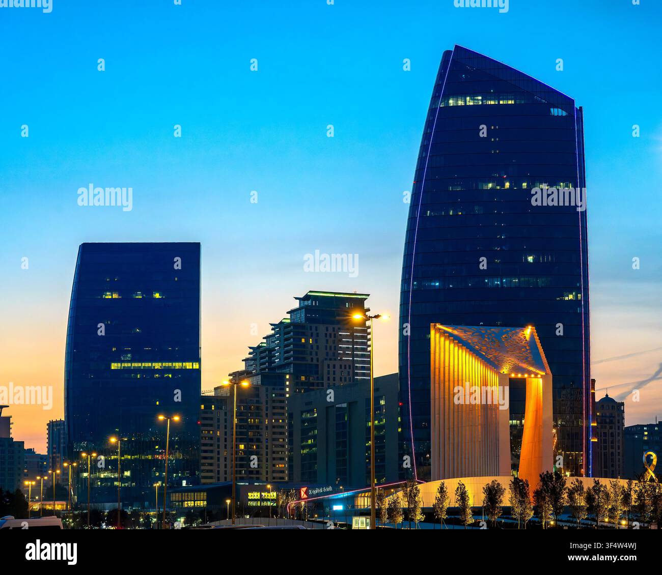 Port Baku Tower 1 et Tower 2 avec l'Arc de Victoire illuminé à l'heure bleue sur le front de mer de Bakou. Bakou, Azerbaïdjan. Banque D'Images