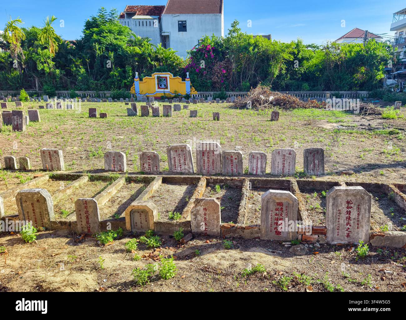 Cimetière traditionnel en plein air avec des rangées de tombes rectangulaires basses bordées de cadres en béton, Hoi An, Vietnam Banque D'Images
