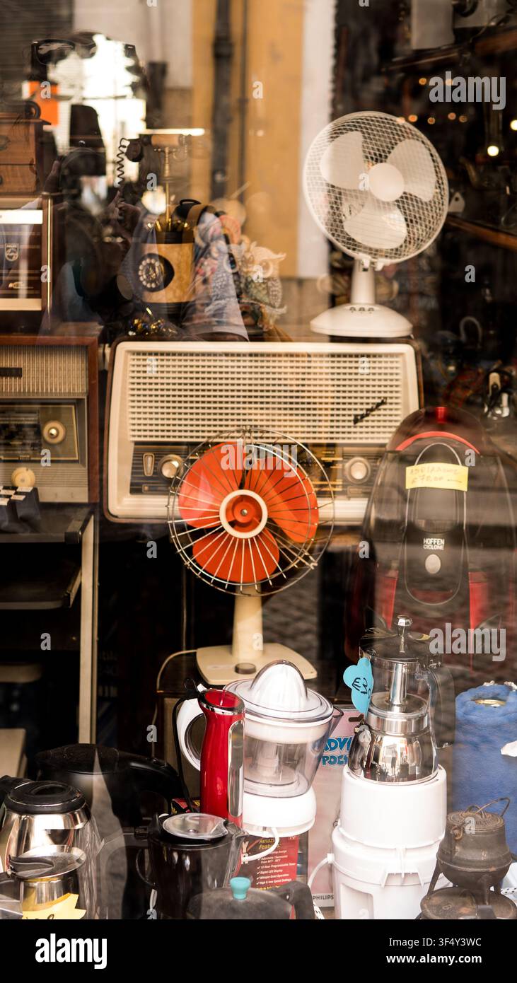 Appareils ménagers vintage, vieux radios et ventilateurs électriques exposés derrière une vitrine de magasin Banque D'Images