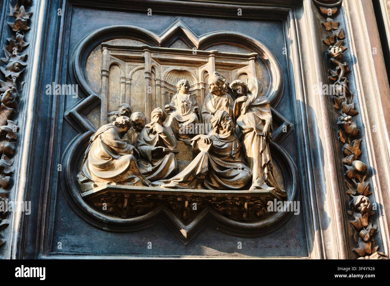 Florence, Italie - Mai 2026 : Panneau de relief en bronze représentant le Christ parmi les docteurs sur la porte nord du baptistère de Florence. Banque D'Images